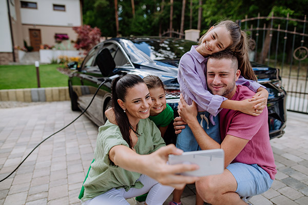 family selfie with EV vehicle